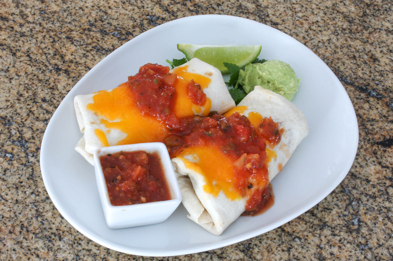 Chicken burritos with salsa and guacamole.