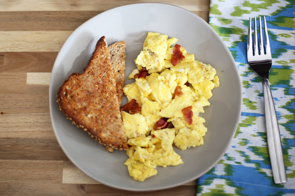 Scrambled eggs with bacon and toast.