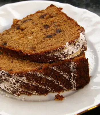 applesauce cake with dates on a plate, topped with powdered sugar