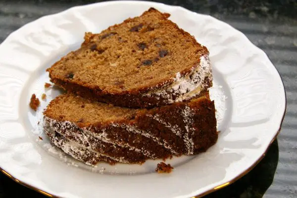 applesauce cake with dates on a plate, topped with powdered sugar