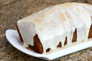 applesauce spice cake on a plate with icing and demerara sugar