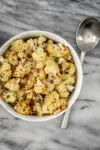 A bowl of air fryer roasted cauliflower ready to eat with parsley garnish.