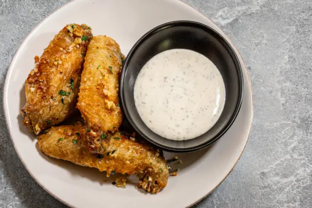 Air fryer chicken wings with ranch dressing for dipping.