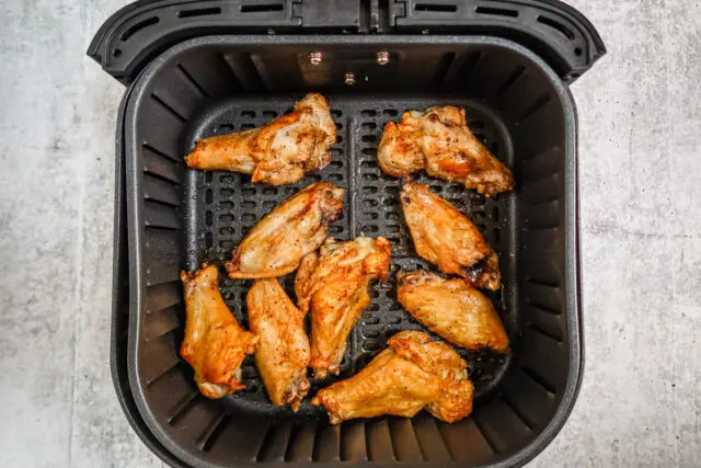 Cooked air fryer chicken wings in the basket.