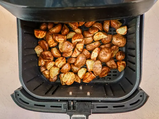 air fryer with cooked potatoes