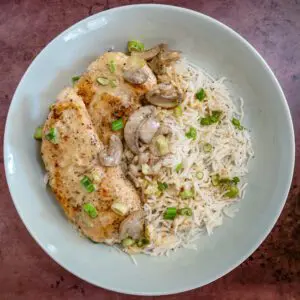 apple brandy chicken breasts and rice with a garnish of green onions