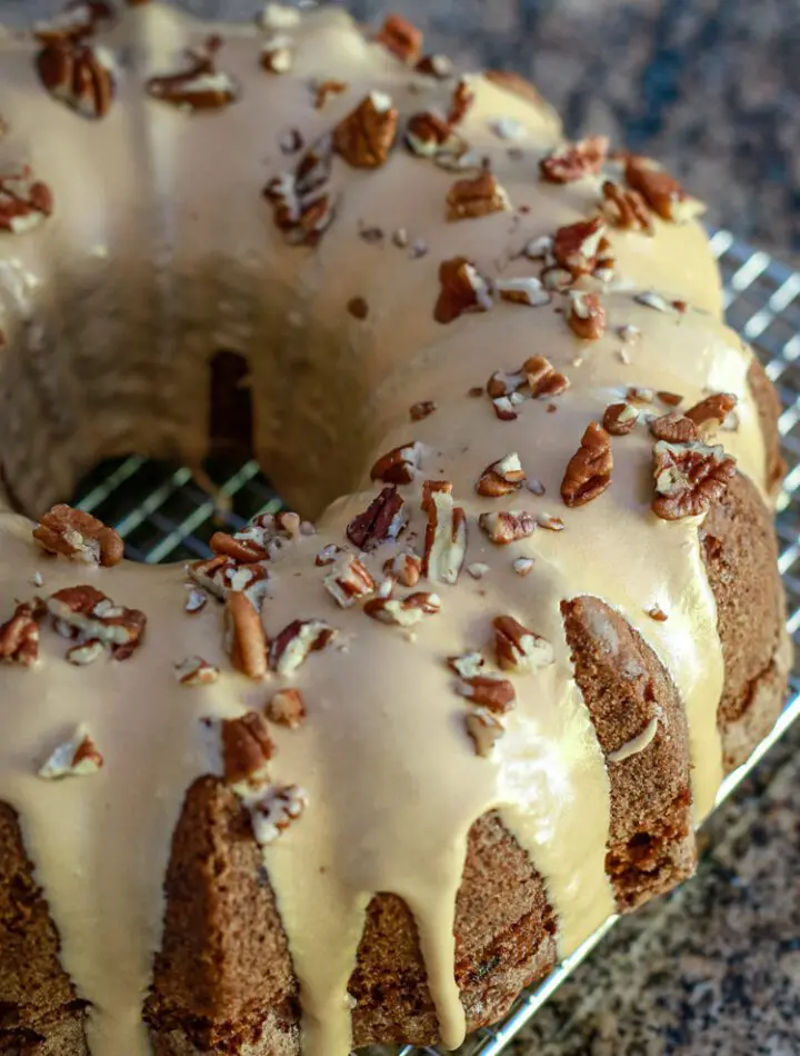 A glazed apple bundt cake on a cooling rack