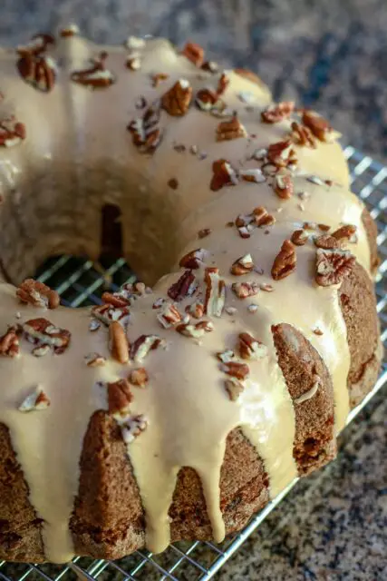 A glazed apple bundt cake on a cooling rack