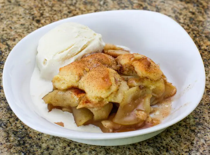 best ever apple cobbler in a serving dish with a scoop of ice cream