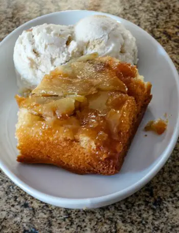 a slice of apple upside down cake with ice cream on the side