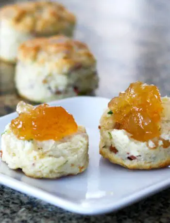 Bacon and chive biscuits on a plate with jam