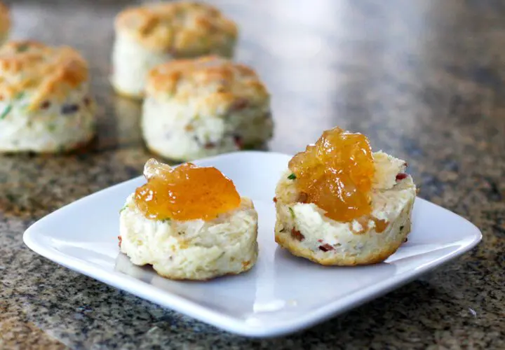 Bacon and chive biscuits on a plate with jam