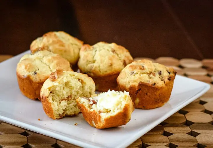 bacon muffins on a square plate, one is buttered