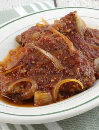 baked cube steaks with bbq sauce on a platter