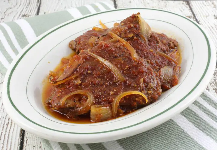 baked cube steaks with bbq sauce on a platter