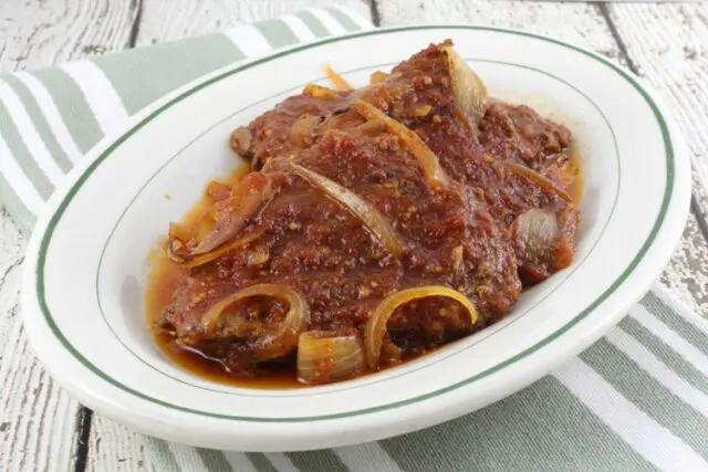 baked cube steaks with bbq sauce on a platter