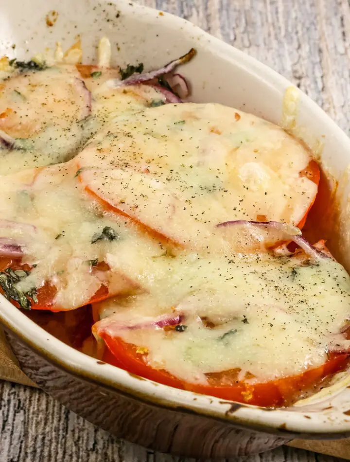 fresh baked tomatoes in a gratin dish with melted fontina cheese