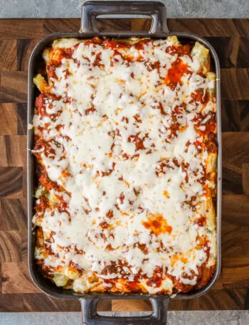 Baked ziti vertical photo on a cutting board.