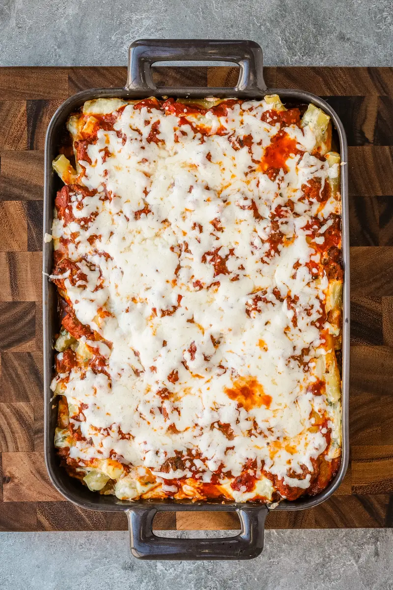 Baked ziti vertical photo on a cutting board.