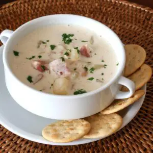 clam chowder with bacon, in a bowl with crackers