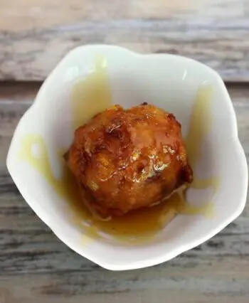 basic corn fritter in a small bowl with golden syrup
