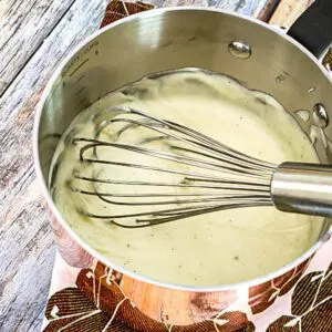 basic white sauce in a pan with whisk