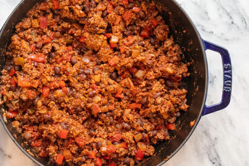 beef and bean mixture in the pan with seasonings.