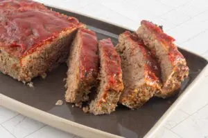 classic beef and pork meatloaf on a serving tray, sliced