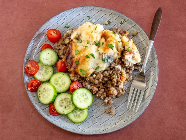 serving of beef and potato casserole with parsley garnish