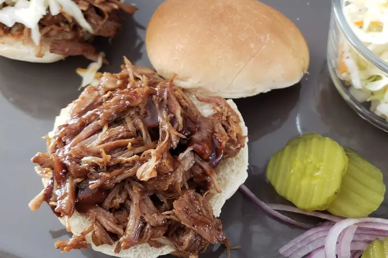 beer braised pork shoulder is shredded and used to make sandwiches or sliders, with slaw on the side.