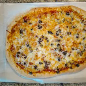 beer pizza crust on the baking sheet with toppings, baked