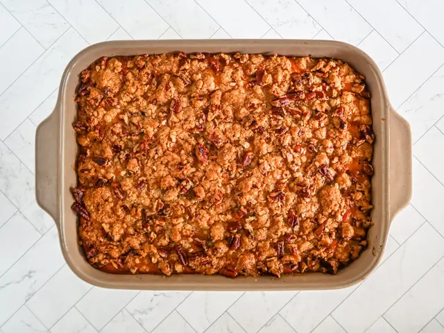 A baking dish with sweet potato casserole with crunchy topping.