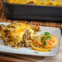 breakfast casserole on a plate with tomatoes