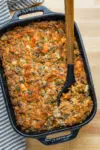 Casserole dish with homemade brioche and sausage stuffing with sage and aromatics.