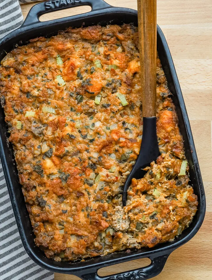 Casserole dish with homemade brioche and sausage stuffing with sage and aromatics.