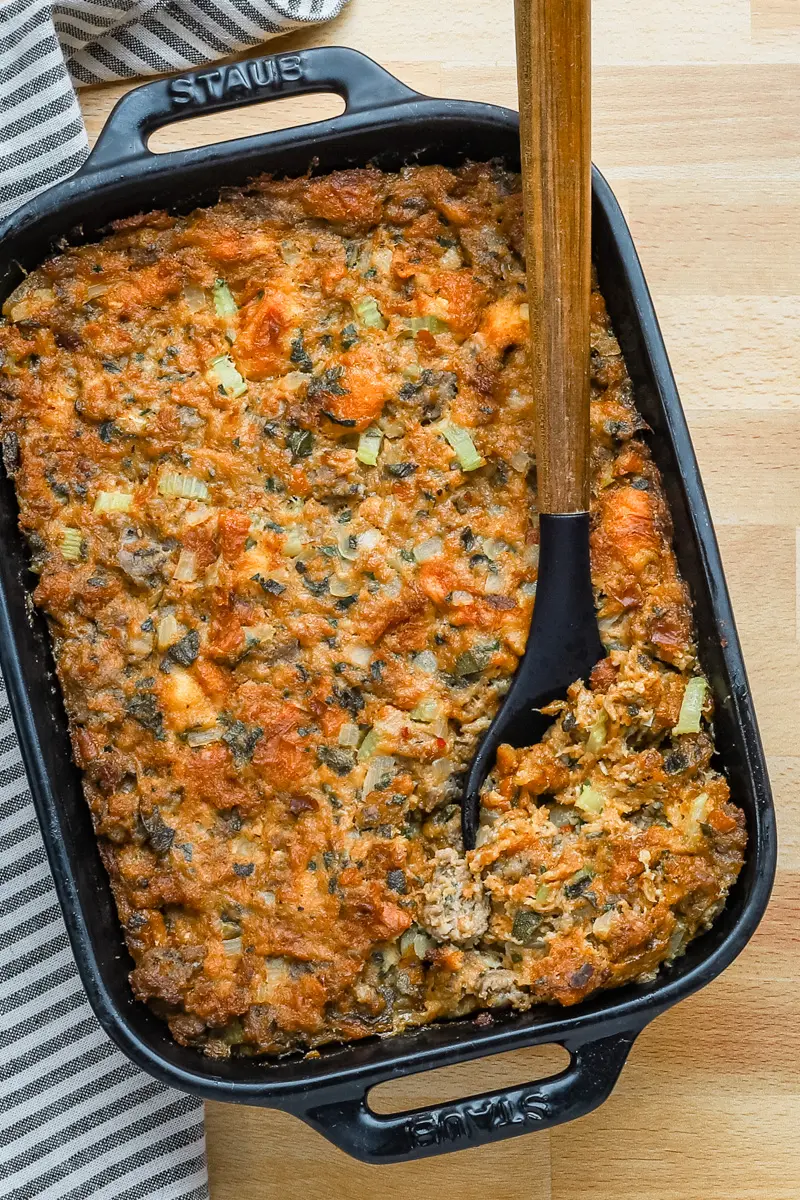 Casserole dish with homemade brioche and sausage stuffing with sage and aromatics.