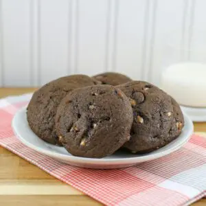 chocolate drop cookies on a plate with a glass of milk in the background