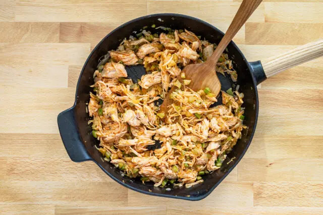 Chicken and vegetables in a skillet for buffalo chicken mac and cheese.