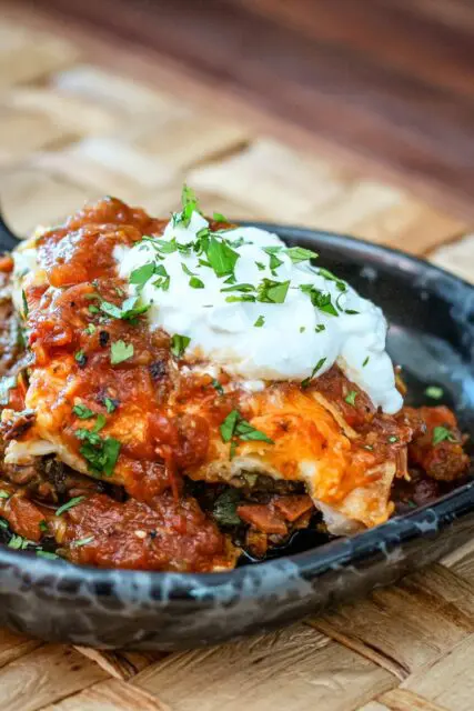 a burrito casserole serving on a pottery plate