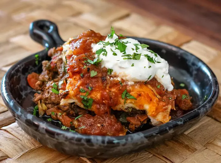 burrito casserole in a serving dish with a dollop of sour cream