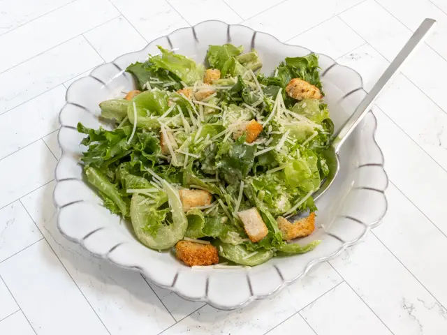 A Caesar salad with dressing.