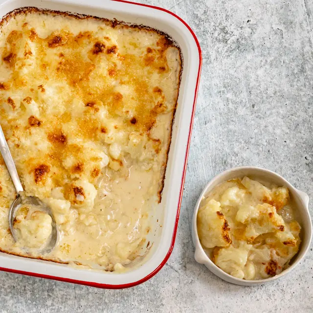 cauliflower cheese in a baking dish and small bowl