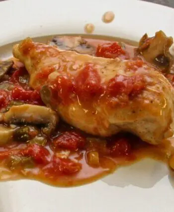 chicken breasts with tomatoes and mushrooms on a plate