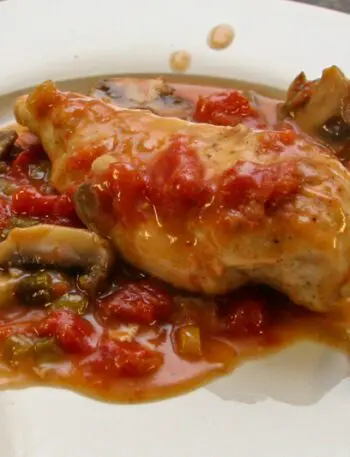 chicken breasts with tomatoes and mushrooms on a plate