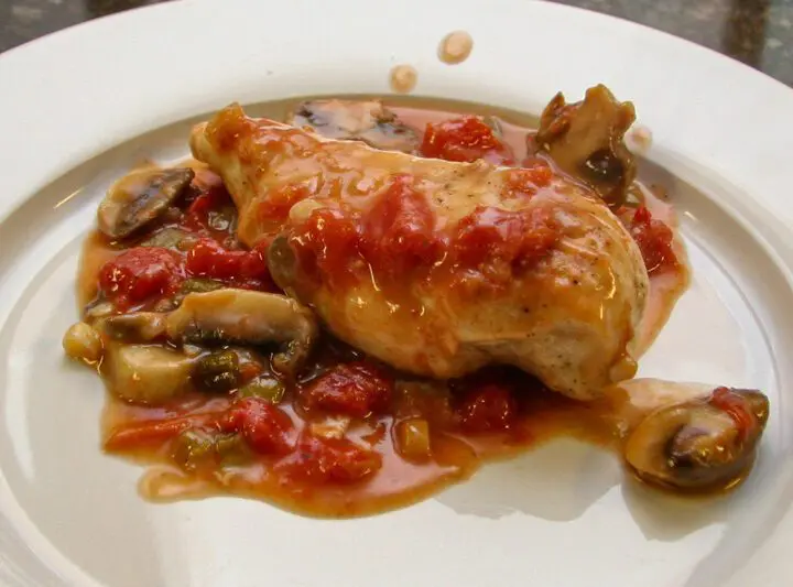 chicken breasts with tomatoes and mushrooms on a plate