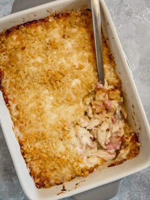 chicken cordon bleu casserole in the baking dish with spoon