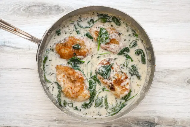 Chicken florentine in a skillet with creamy sauce, ready to serve and enjoy.