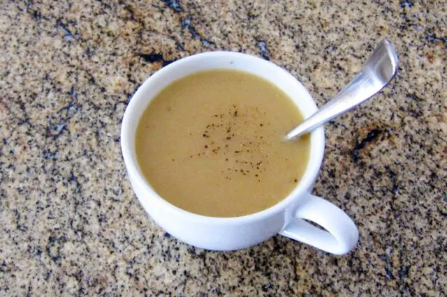 chicken gravy in a cup with spoon