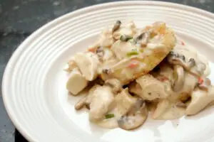 chicken and mushrooms with fried grits cakes on a plate