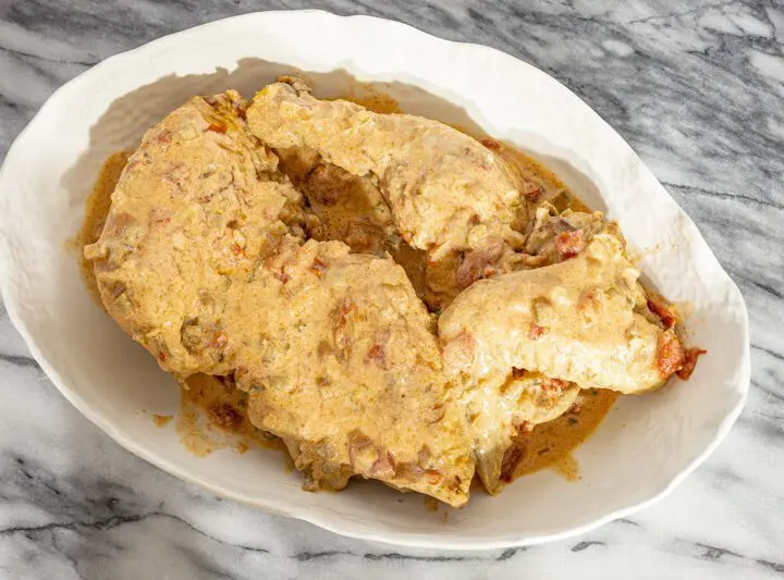 chicken paprikash with sour cream and paprika in a serving dish.